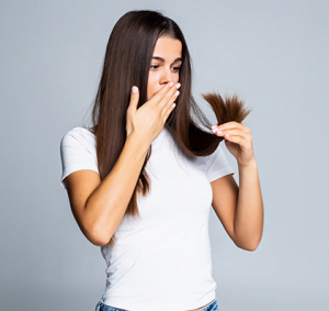 A photo of woman looking shocked after seeing hair breakage