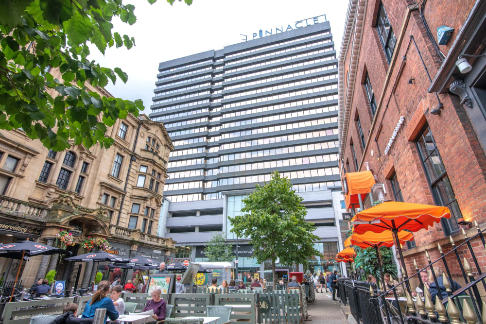 Vibrant photo of a sky scrapper surrounded by roads and older buildings in Leeds.